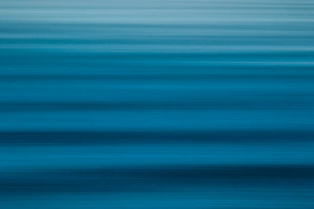 Smooth waves or swell lines rolling into the coast.