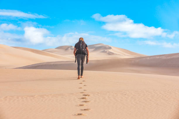 istock Young adventurous man walking into dry arid desert landscape 1994524230