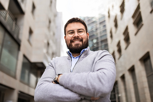 Portrait of a confident young businessman standing against an urban background