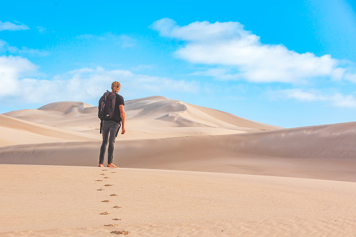Man walking barefoot on sand