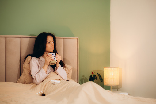Young woman feel sick and unwell on bed. High quality photo