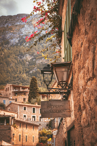 An antique lamp gracefully suspended from a brick wall in the town of Valldemossa in Mallorca