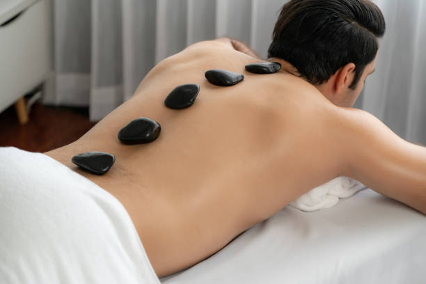 hot stone massage at spa salon in luxury resort. quiescent - lastone therapy massaging stone shiatsu - fotografias e filmes do acervo