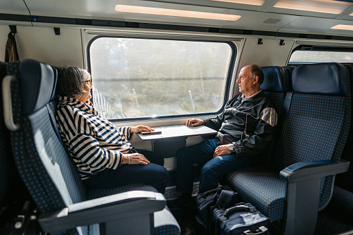 Beautiful senior couple riding in a train in Switzerland.