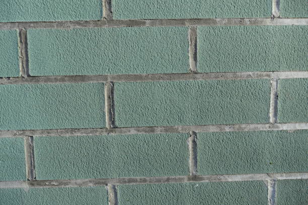 Close up of blue green brick wall with light grey mortar joints