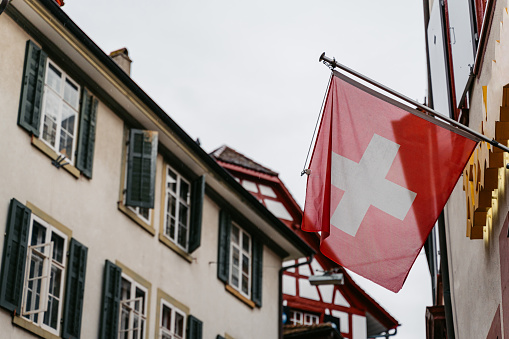 Swiss flag waving in the wind on a building in Switzerland.