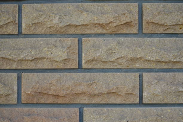 istock Closeup of beige brick veneer wall with grey mortar joints 1994633724