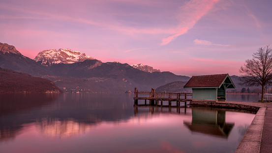 Landscape of Lake Annecy surrounded by mountains at sunset in winter around Saint-Jorioz