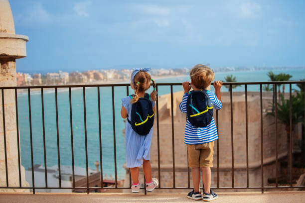 istock Little visitors of Peniscola castle admire coastline view 1994640064