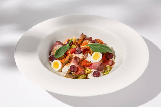 istock Roast Beef Salad with Quail Eggs and Vegetables on Shadowed White Presentation 1994644401