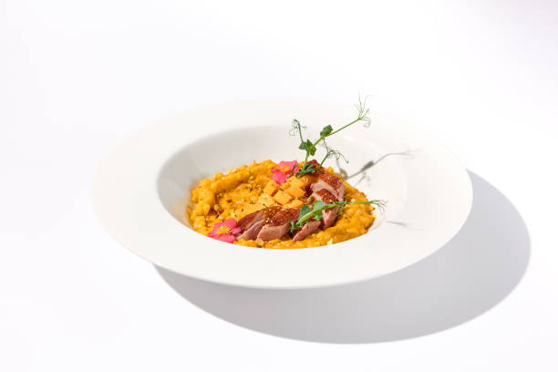 istock Duck breast with pumpkin risotto on a white plate, a gourmet meal for fine dining and restaurant menus 1994644416