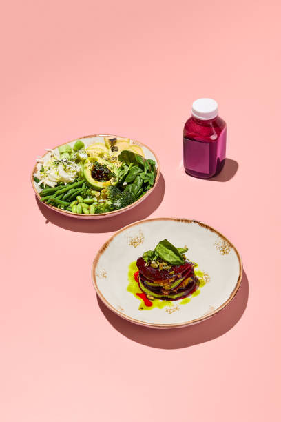 istock Vegan salad plates with smoothie bottle; showcasing a nutritious and colorful meal on a monochromatic pink backdrop 1994644980