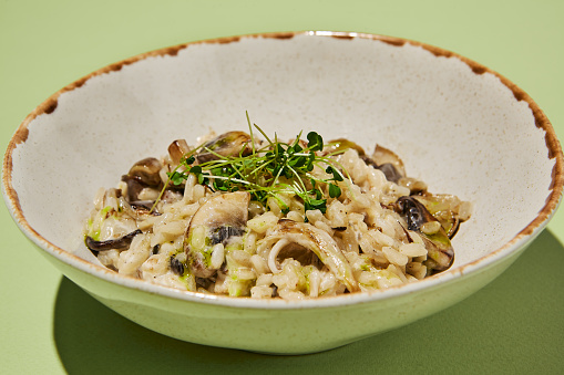 Macro shot of creamy mushroom risotto with truffle oil, garnished with fresh herbs, a luxurious comfort food experience.