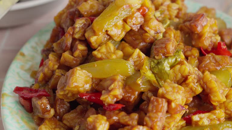 Close-up of Indonesian tempeh orek with sambal on a table, vibrant colors, traditional cuisine