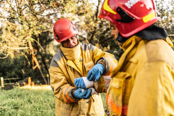 istock Firefighter bandaging his colleague's hand outdoors 1994700431