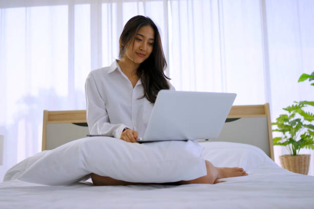 istock Young woman wake up and work at bedroom. 1994718995