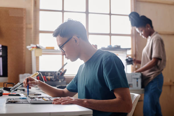 istock Young Caucasian Technician Using Wireless Soldering Iron for Repairing 1994721149