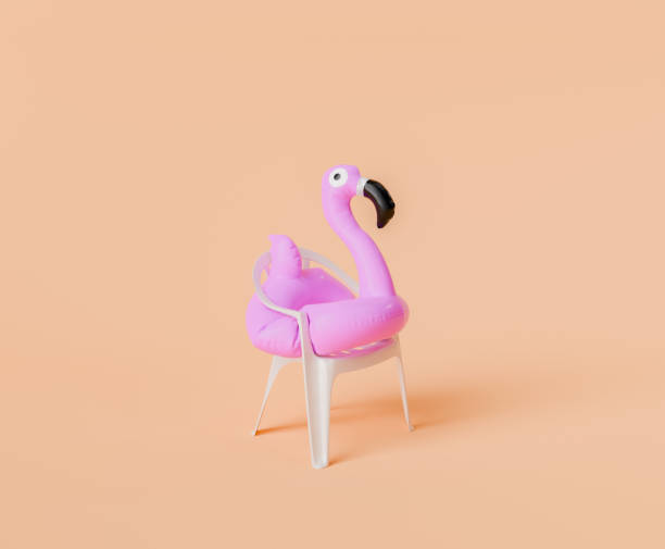 istock Pink Flamingo Float on White Plastic Chair Against Peach Background 1994731844