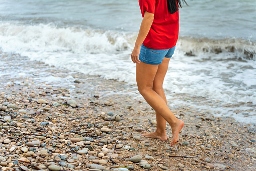 Middle aged woman walking barefoot on the beach. Time for yourself.