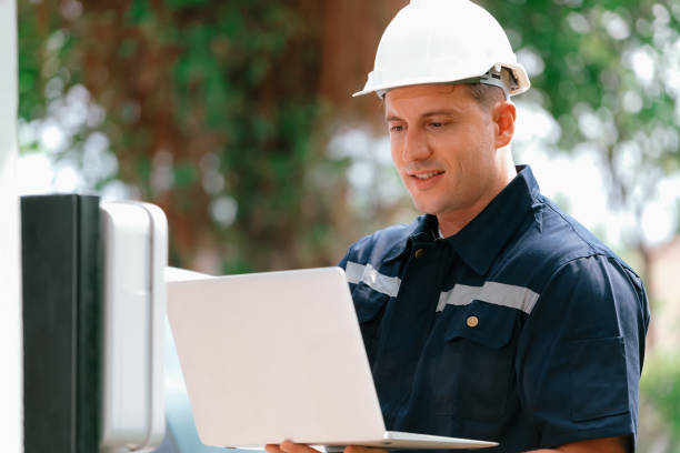 istock Qualified technician working with laptop for home EV station. Synchronos 1994771422
