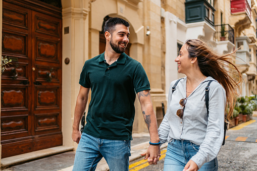 Beautiful young couple walking through the city in Valletta Malta.