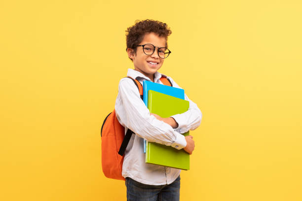 istock Confident black student teen with glasses and backpack on yellow 1994799112
