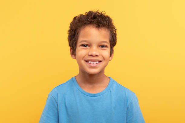 istock Smiling boy in blue t-shirt against yellow backdrop 1994799695