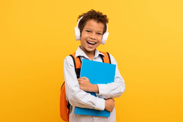 istock Boy with headphones and book, orange bag 1994799709