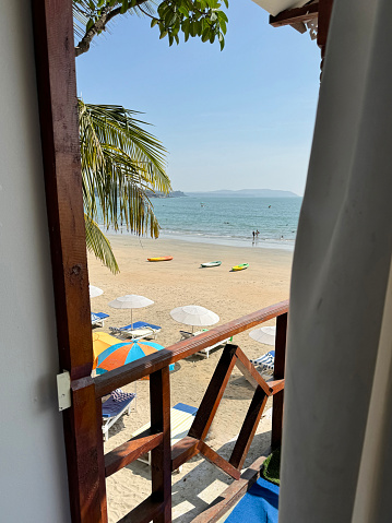 Stock photo showing close-up view of wooden beach hut terrace balcony of a beach hut shack. These beach huts are cheap beachfront treehouse style accommodation with sea view.