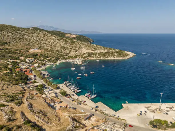 Photo of Port on a Greek island with blue turquoise water with many boats and yachts on the water in Greece, Zakynthos. Aerial drone photo of Agios Nikolaos - a small port on the island of Zante.