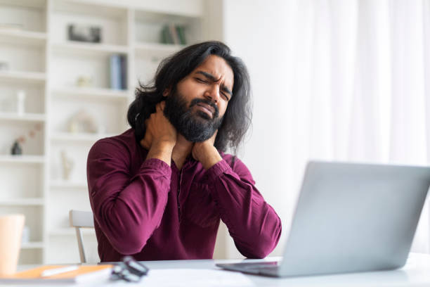 istock Indian freelancer man feeling neck pain while working with laptop at home 1994830095