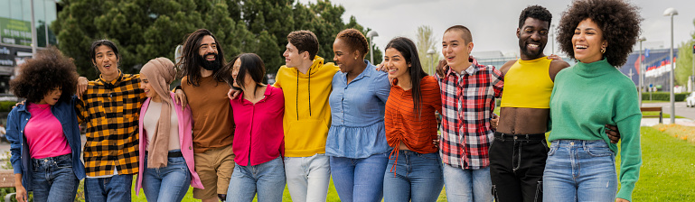 front view group of multiracial and diverse friends lined up in row hugging