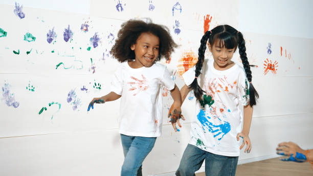 istock Playful children playing and running with colorful stained hand. Erudition. 1994848672