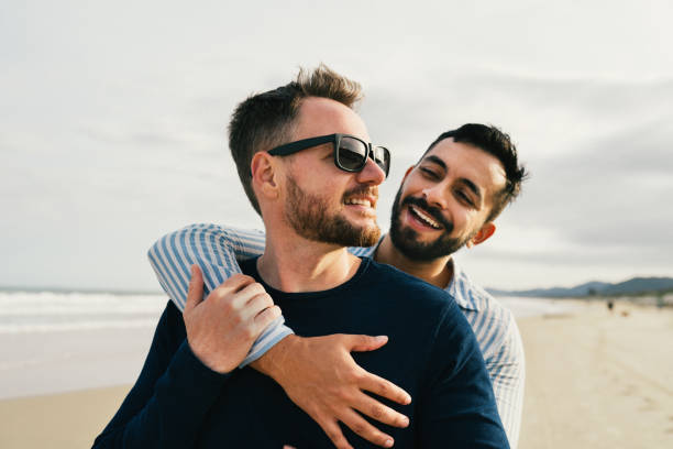 istock Loving young gay couple hugging while standing together on a beach 1994850285
