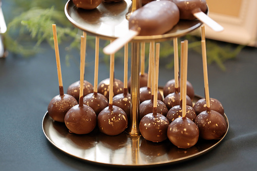 Chocolate balls on the stick on catering table and empty space for text