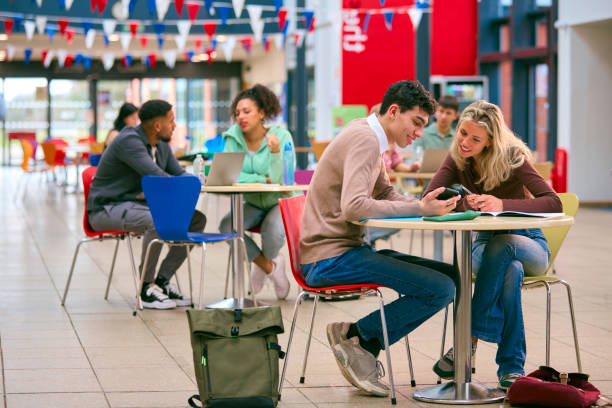 istock Two College Or University Students With Mobile Phone Working Together In Study Area 1994861481