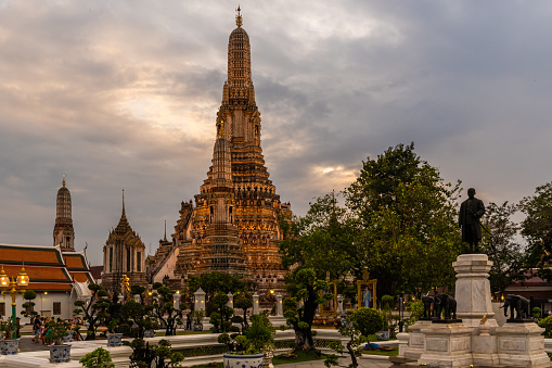 Bangkok, Thailand - January 25th, 2024: The famous Wat Arun getting illuminated when twilight starts.
