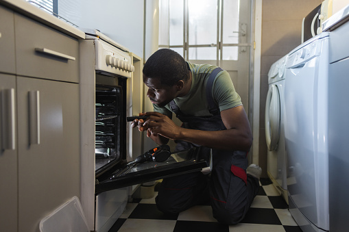 Photo of African American handyman working at the customer's home.
