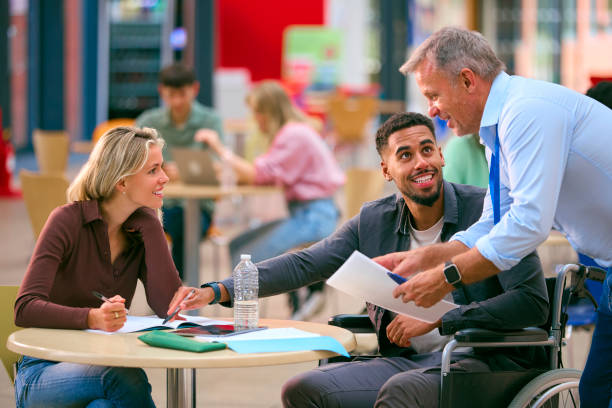 istock Tutor Talking With Two College Or University Students With One In Wheelchair Working In Study Area 1994872792