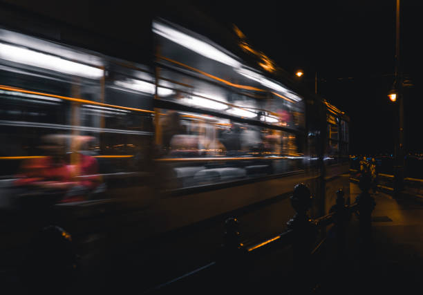 istock a person standing on a train platform as it goes by at night 1994888544