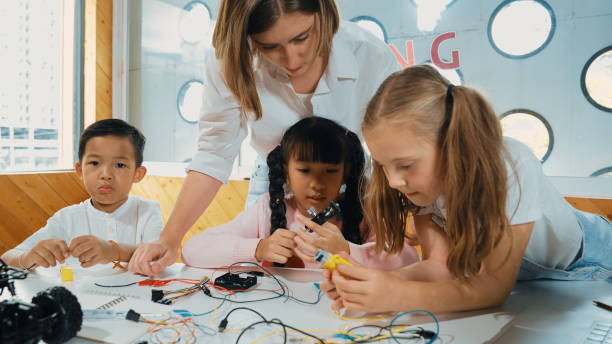 istock Teacher looking at children while diverse student looking at screen. Erudition. 1994890693