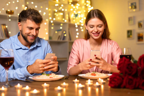 istock Couple at dinner, distracted by their smartphones 1994892929