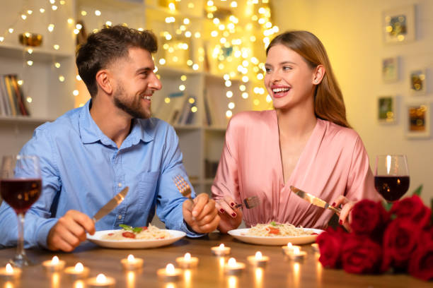 istock Joyful couple dining with wine and roses, enjoying conversation 1994894106