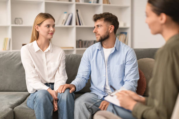 istock Young couple sitting on sofa engaging in couples therapy indoor 1994911857