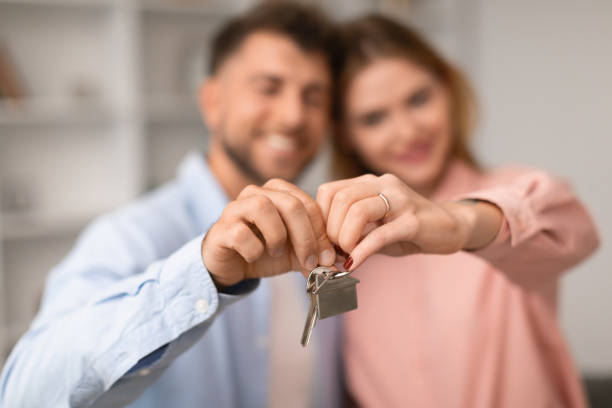 istock Happy Young Spouses Holding New Apartment Key Hugging Indoor 1994912407