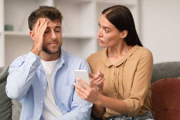 istock Jealous millennial wife shows smartphone confronting husband at home 1994912990