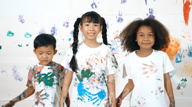istock Diverse students put hands up together show colorful stained hands. Erudition. 1994924789