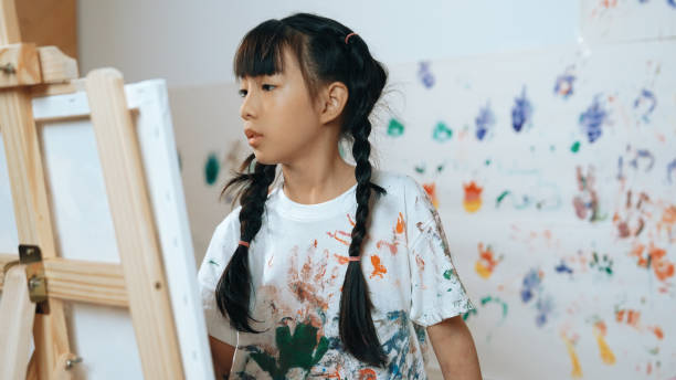 istock Young student painted or draw canvas at stained wall in art lesson. Erudition. 1994925861