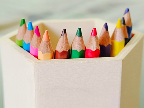 Defocused view of colour pencils in a wooden box
