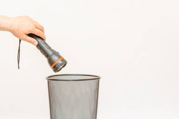 the flashlight is thrown into the trash,can for disposal and recycling.white,gray background,selective focus,copy space. - 11275 foto e immagini stock